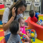 nfant daycare caregiver gently holding a baby in a safe, calm daycare environment
